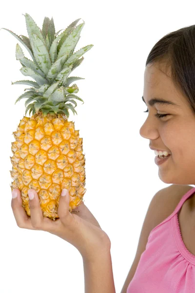 Nuori tyttö tilalla ananas ja hymyilevä — kuvapankkivalokuva