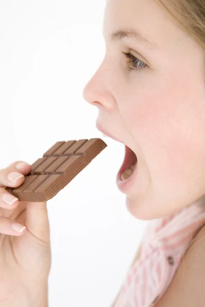Adolescente comendo barra de chocolate — Fotografia de Stock