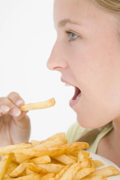 Дівчинка - підліток їсть картоплю фрі. — стокове фото