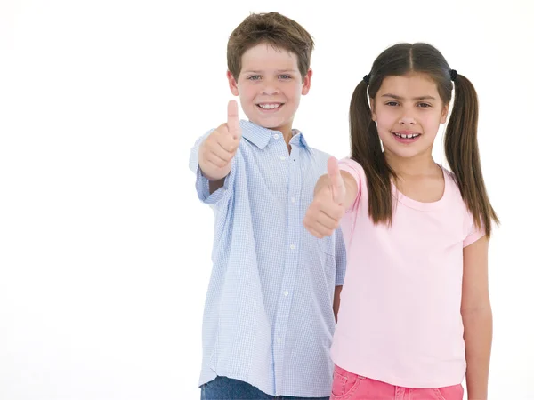 Brother and sister giving thumbs up smiling — Stock Photo, Image