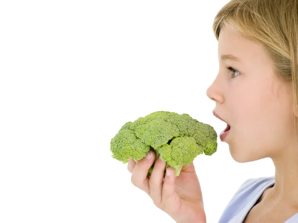 年轻的女孩吃西兰花 — 图库照片