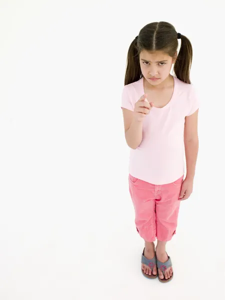 Young girl pointing and frowning — Stock Photo, Image
