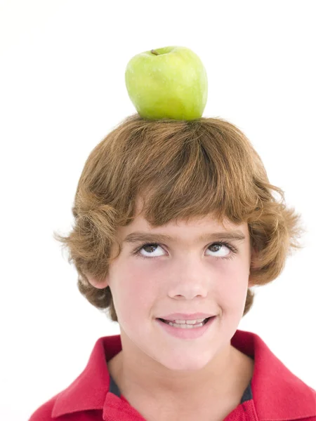 Молодий хлопчик з яблуком на голові посміхається — стокове фото