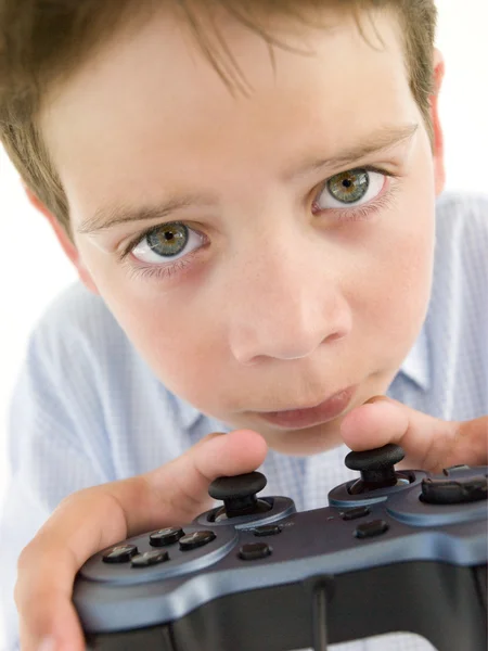 Young boy using videogame controller and concentrating — Stock Photo, Image