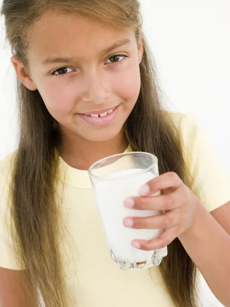 笑みを浮かべてミルクのガラスを持つ若い女の子 — ストック写真