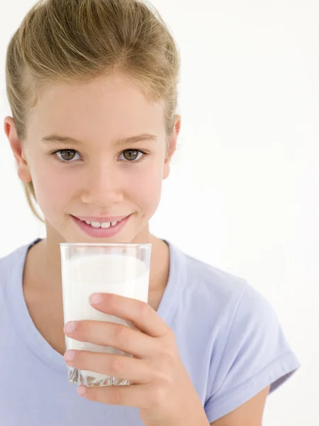 Ung flicka med glas mjölk leende — Stockfoto