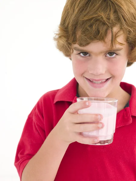 Мальчик со стаканом молока улыбается — стоковое фото