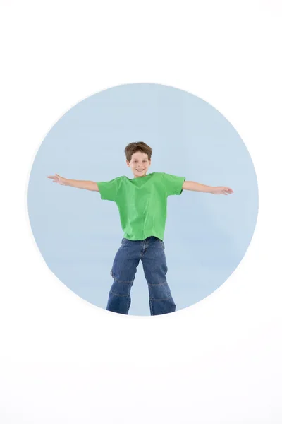 Young boy standing with arms out smiling — Stock Photo, Image