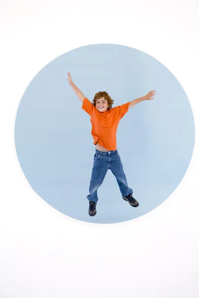 Kleiner Junge springt lächelnd mit den Armen heraus — Stockfoto