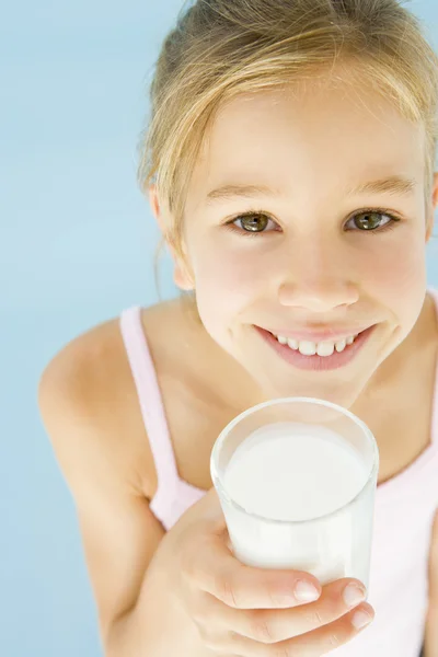 笑みを浮かべてミルクのガラスを持つ若い女の子 — ストック写真