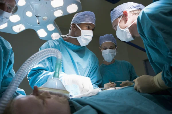 Три Хирурга Оперирующие Пациента — стоковое фото