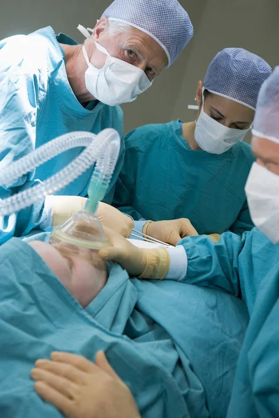 Üç cerrahlar bir hastanın ameliyat — Stok fotoğraf
