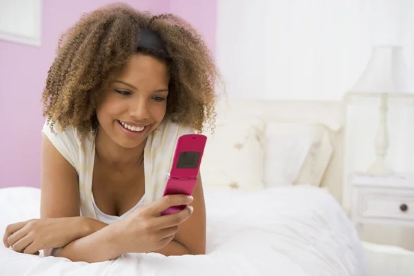 Genç Kızın Cep Telefonu Kullanarak Yatakta Yatarken — Stok fotoğraf