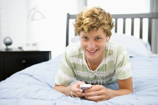Mp3 Çalar Için Dinleme Yatakta Yatan Genç Çocuk — Stok fotoğraf