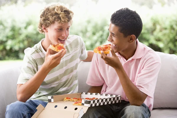 十几岁的男孩坐在沙发上一起吃比萨 — 图库照片
