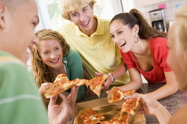Grupp tonåringar äter pizza — Stockfoto