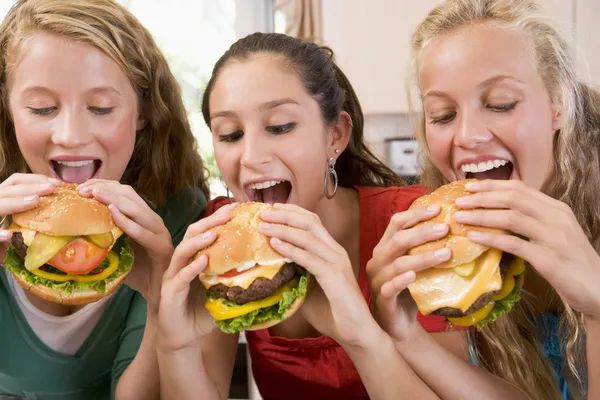 Adolescente ragazze mangiare hamburger — Foto Stock