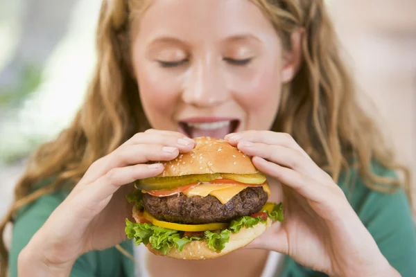 Adolescente chica comiendo hamburguesas — Foto de Stock