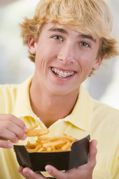 Мальчик-подросток ест картошку фри — стоковое фото