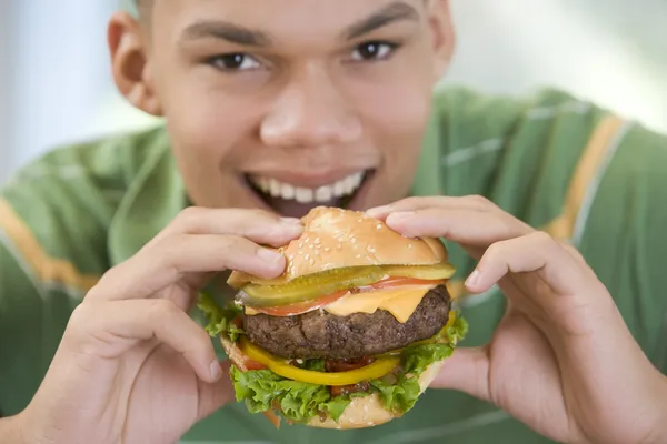 Adolescente chico comiendo hamburguesa — Foto de Stock