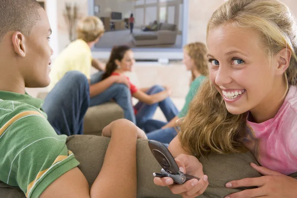 Adolescenti che escono davanti alla televisione utilizzando i telefoni cellulari — Foto Stock