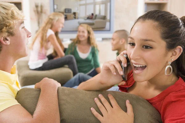 Les adolescents traînant devant la télévision à l'aide de téléphones mobiles — Photo