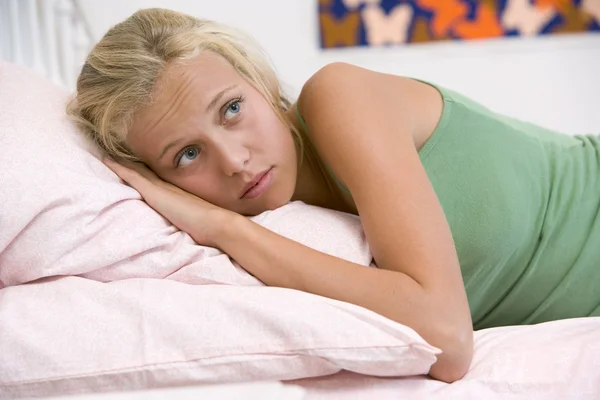 Nastoletnia dziewczyna leżąc na łóżku — Zdjęcie stockowe