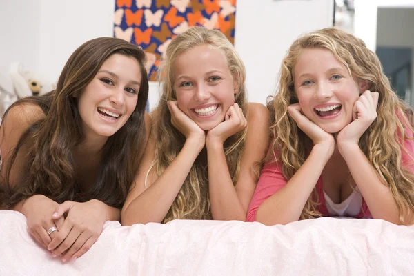 Meninas adolescentes deitadas na cama usando o telefone móvel — Fotografia de Stock