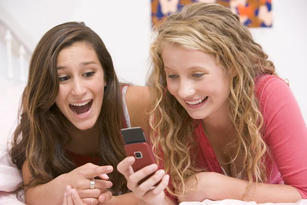 Adolescentes Acostadas Cama Usando Teléfono Móvil —  Fotos de Stock