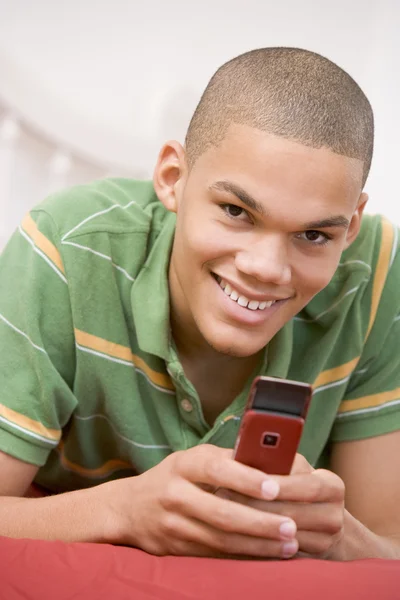 Ragazzo Adolescente Sdraiato Sul Letto Utilizzando Telefono Cellulare — Foto Stock