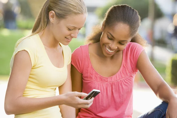 Tiener Meisjes Zitten Buiten Spelen Met Mobiele Telefoon — Stockfoto