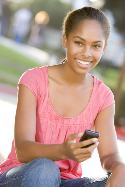 Teenage Girl Sitting Outdoors Using Mobile Phone — Stock Photo, Image