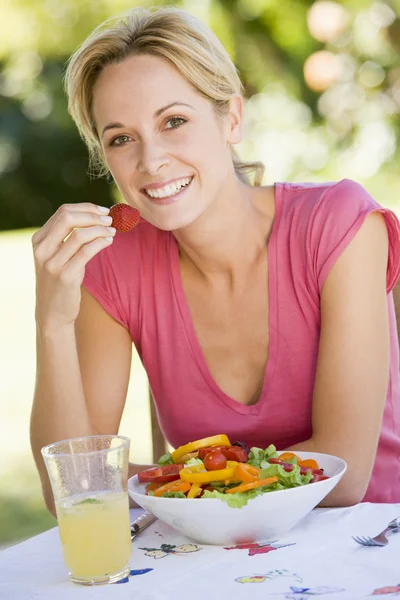 Mulher desfrutando de uma salada em um jardim — Fotografia de Stock