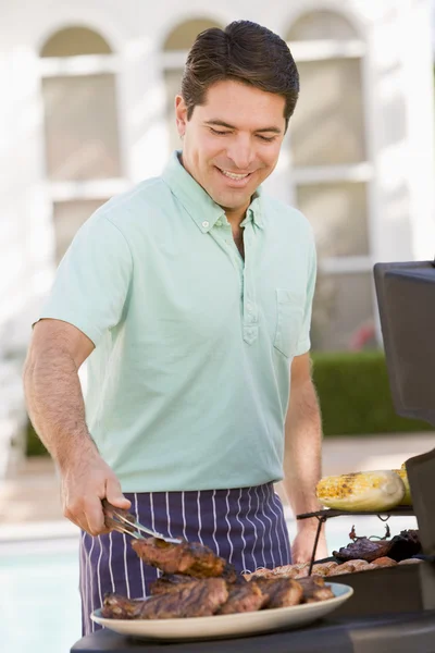 Человек барбекю в саду — стоковое фото