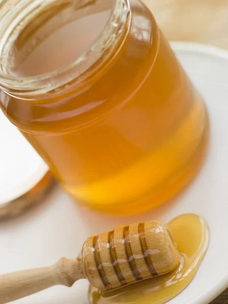 Pot met honing en lepel — Stockfoto