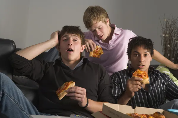 Tonårspojkar äta pizza — Stockfoto