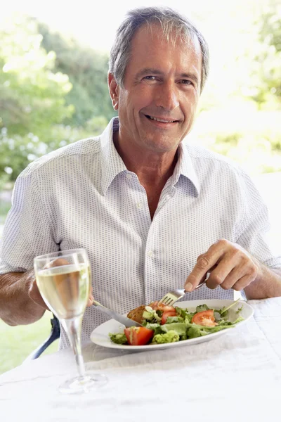 Senior man eten een al fresco lunch — Stockfoto