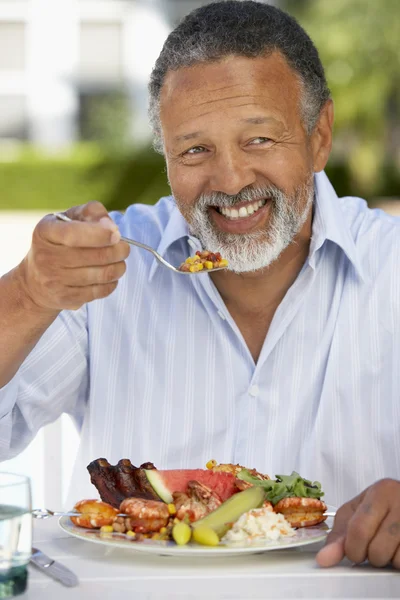 Середнього віку людина вечерями на відкритому повітрі — стокове фото