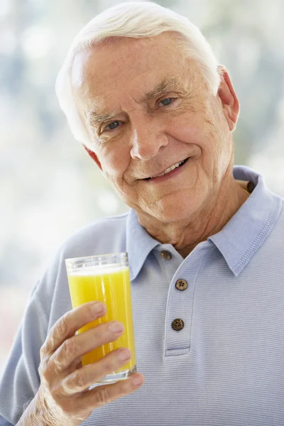 Człowiek Uśmiecha Się Kamery Picie Soku Pomarańczowego — Zdjęcie stockowe