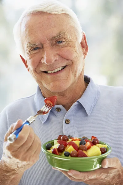 Homem sênior comendo salada de frutas frescas — Fotografia de Stock