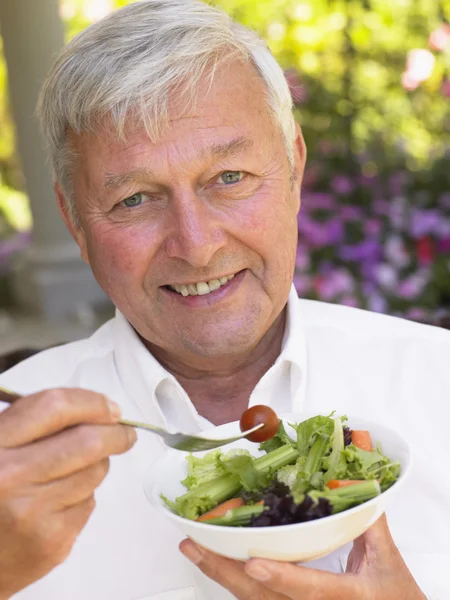 Hombre mayor comiendo ensalada fresca — Foto de Stock