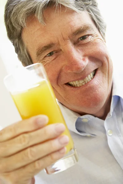Hombre Mayor Sonriendo Cámara Bebiendo Jugo Naranja — Foto de Stock