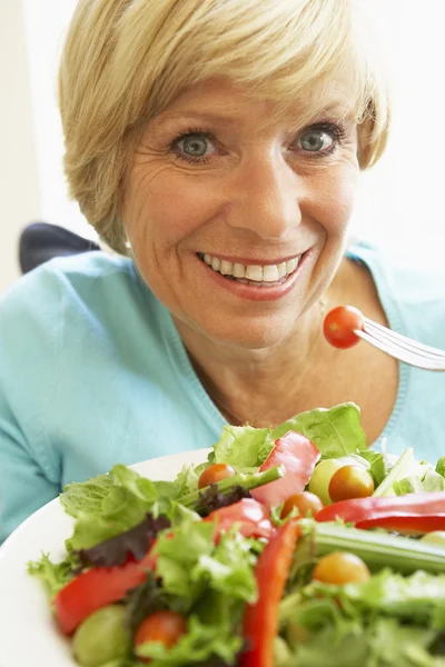 Mujer de mediana edad comiendo ensalada saludable — Foto de Stock