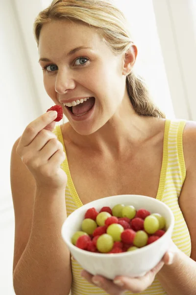 Mladá žena jíst mísa s ovocem — Stock fotografie