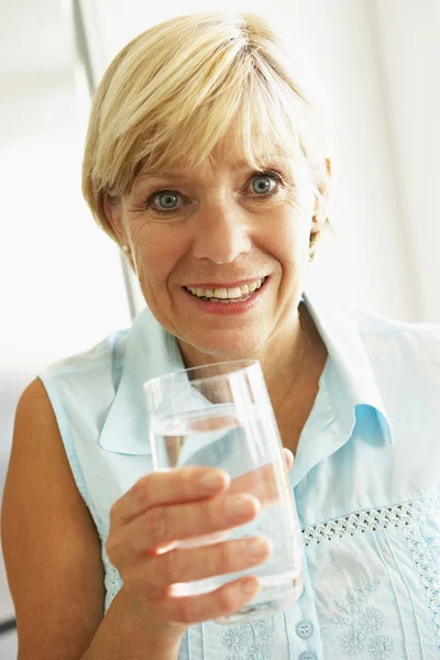 Mulher de meia-idade bebendo um copo de água — Fotografia de Stock