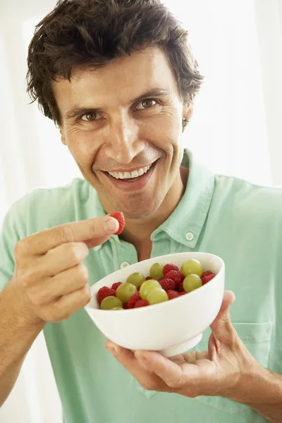 Взрослый мужчина ест свежие фрукты — стоковое фото
