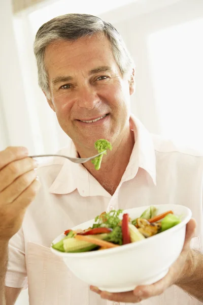 Людина середнього віку їсть здоровий салат — стокове фото