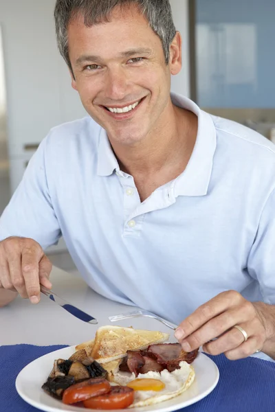 Hombre de mediana edad comiendo desayuno frito poco saludable — Foto de Stock