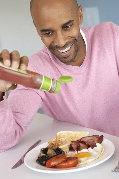 Hombre de mediana edad comiendo desayuno frito poco saludable —  Fotos de Stock