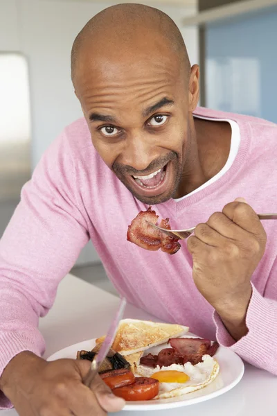 Uomo di mezza età che mangia colazione fritta malsana — Foto Stock